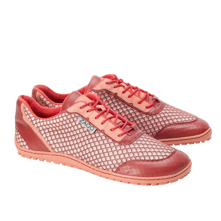 Wir präsentieren den TOQIO Coral von ZAQQ, ein Paar rote Sneaker mit Wabenmuster und strukturierter Sneakersohle. Mit eleganten Wildlederakzenten und einem schlanken Design bieten diese Barfußschuhe bei jedem Schritt Stil und Komfort.