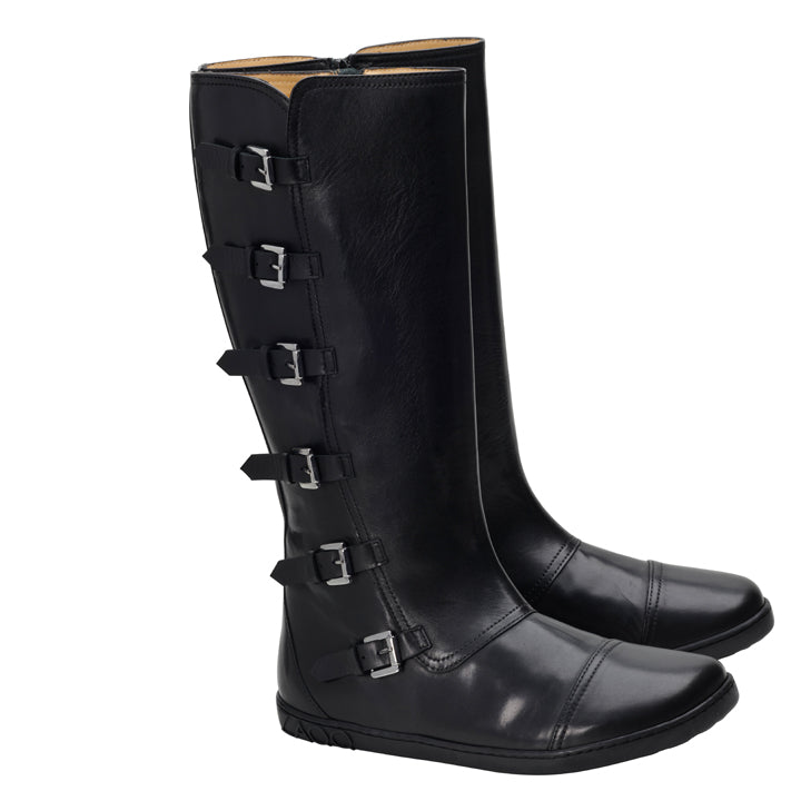 Ein Paar PAULIQ Black Boots von ZAQQ in hohem Design aus schwarzem Leder mit fünf verstellbaren Schnallenriemen an der Seite. Diese Stiefel zeichnen sich durch einen schlanken Stil und leicht abgerundete Zehenpartie aus, die bei jedem Schritt ein einzigartiges Barfußgefühl vermitteln.