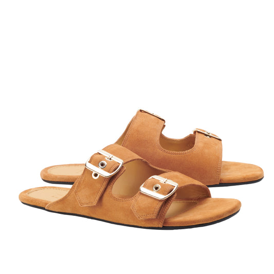 Ein Paar UQO Brown-Sandalen von ZAQQ mit einer velourslederähnlichen Textur und jeweils zwei silbernen Schnallen. Mit offenen Zehen und einer flachen Sohle versprechen diese Komfort-Sandalen Komfort für lässige Anlässe. Vor einem weißen Hintergrund wird ihr elegantes Design perfekt hervorgehoben.