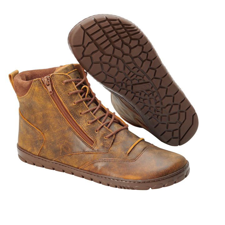 Ein Paar PARQER Cognac High-Top-Schnürboots von ZAQQ, gefertigt aus hochwertigem Nappaleder in einem satten Braunton. Sie verfügen über Schnürungen vorne und praktische seitliche Reißverschlüsse. Die Sohlen haben ein strukturiertes Muster für besseren Halt. Ein Stiefel wird aufrecht präsentiert, während der andere geneigt ist, um das Sohlendesign hervorzuheben.