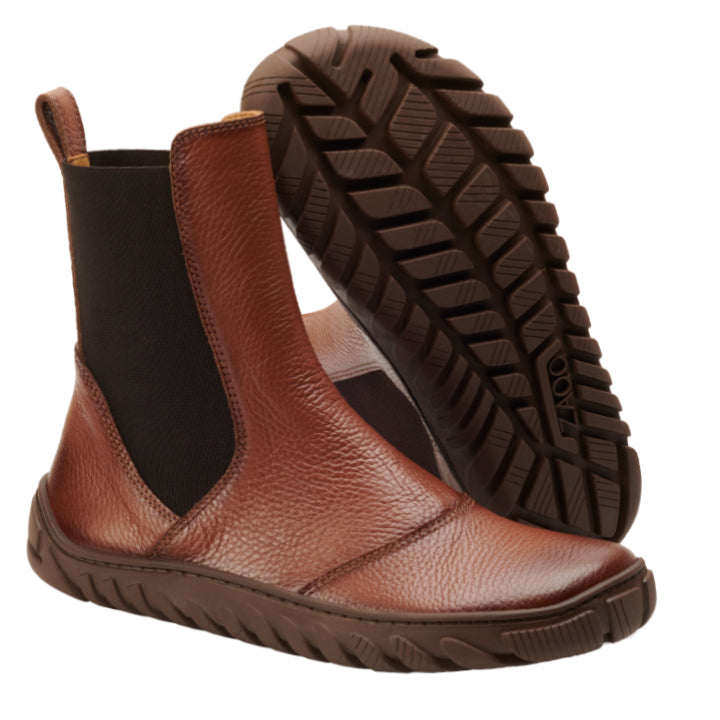 Die ELASTIQ Brown-Stiefel von ZAQQ sind aus hochwertigem braunem Leder gefertigt und verfügen über schwarze elastische Seitenteile und strukturierte braune Gummisohlen. Ein Stiefel steht aufrecht und zeigt sein Seitenprofil, während der andere so positioniert ist, dass die Profilsohle hervorgehoben wird. Entworfen für Stil und Komfort mit hochwertigem Nappaleder.