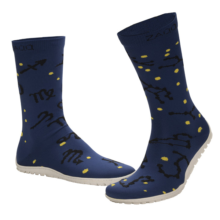 Die SOQQ Zodiac Blue-Schuhe von ZAQQ zeigen eine Strickgewebe-Textur mit einem dunklen Design mit schwarzen Sternbildmustern und gelben sternähnlichen Punkten. Die blauen Schuhe im Sockenstil werden stilvoll durch weiße Sohlen ergänzt und verbinden Mode mit Komfort.