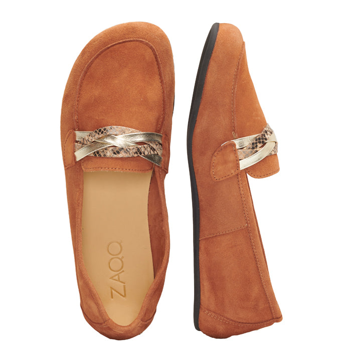 Ein Paar QERP Cognac-Loafer von ZAQQ aus edlem Wildleder mit einem dekorativen geflochtenen Metallriemen über der Oberseite. Diese von Barfußschuhen inspirierten Schuhe werden von oben und von der Seite gezeigt, wobei ihr schlankes Design und die flachen Sohlen für eine stilvolle und bequeme Passform hervorgehoben werden.