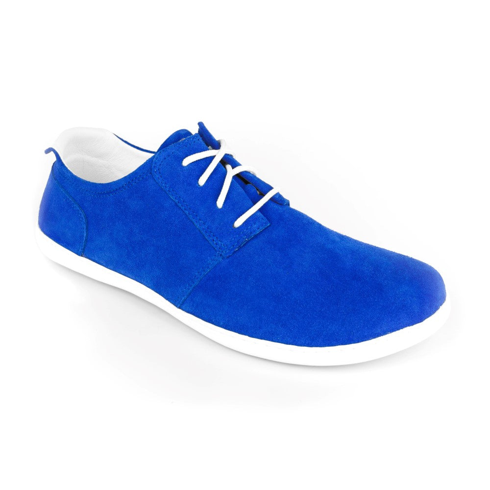 Der PIQUANT Velours Cobalt von ZAQQ, ein leuchtend kobaltblauer Wildlederschuh mit weißen Schnürsenkeln und einer eleganten weißen Sohle, präsentiert auf einem makellosen Hintergrund, fängt die Essenz der Kollektion ein.