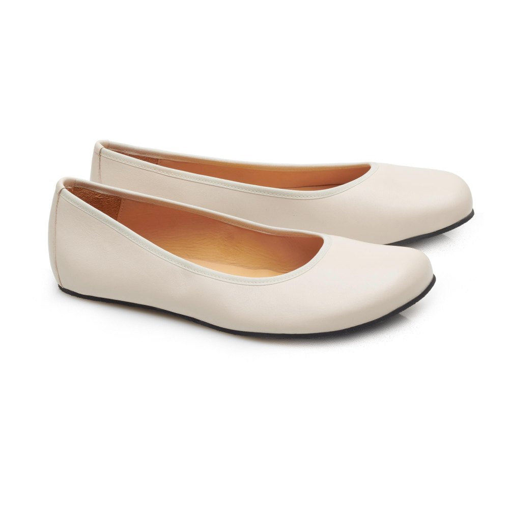 „QARMA Beige“ von ZAQQ ist ein Paar Ballerinas aus luxuriösem Nappaleder mit abgerundeter Spitze und tiefem Ausschnitt an den Seiten, elegant auf weißem Hintergrund präsentiert.