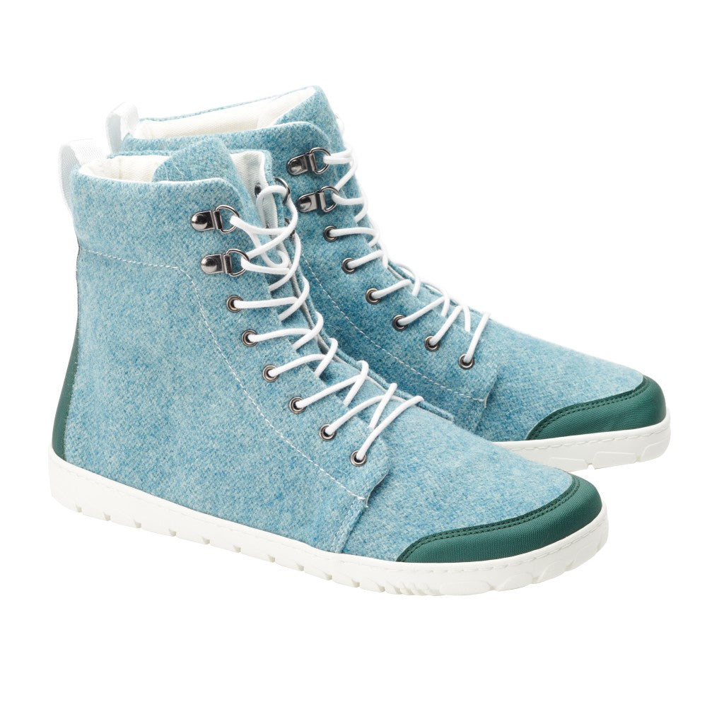 Wir präsentieren den QICE Green von ZAQQ: Ein Paar stylische High-Top-Sneaker aus hellblauem Stoff mit weißen Schnürsenkeln, aufgewertet durch dunkelgrüne Akzente an Zehen und Ferse. Inspiriert vom Barfußschuh-Design verfügen diese Schuhe über eine strapazierfähige weiße Gummisohle für müheloses Gehen.