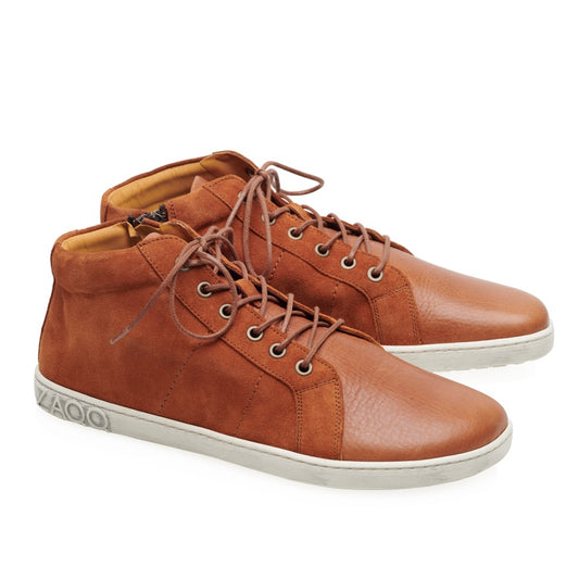 Wir präsentieren den anspruchsvollen QORE Mid Sierra von ZAQQ, gefertigt aus verschiedenen Lederarten für einen eleganten Auftritt. Diese High-Top-Sneaker aus braunem Leder haben weiße Sohlen und hellbraune Innenseiten, ergänzt durch lässig geknotete Schnürsenkel. Der Markenname ist für zusätzliche Unterscheidungsmerkmale fachmännisch in der Nähe der Ferse eingeprägt.