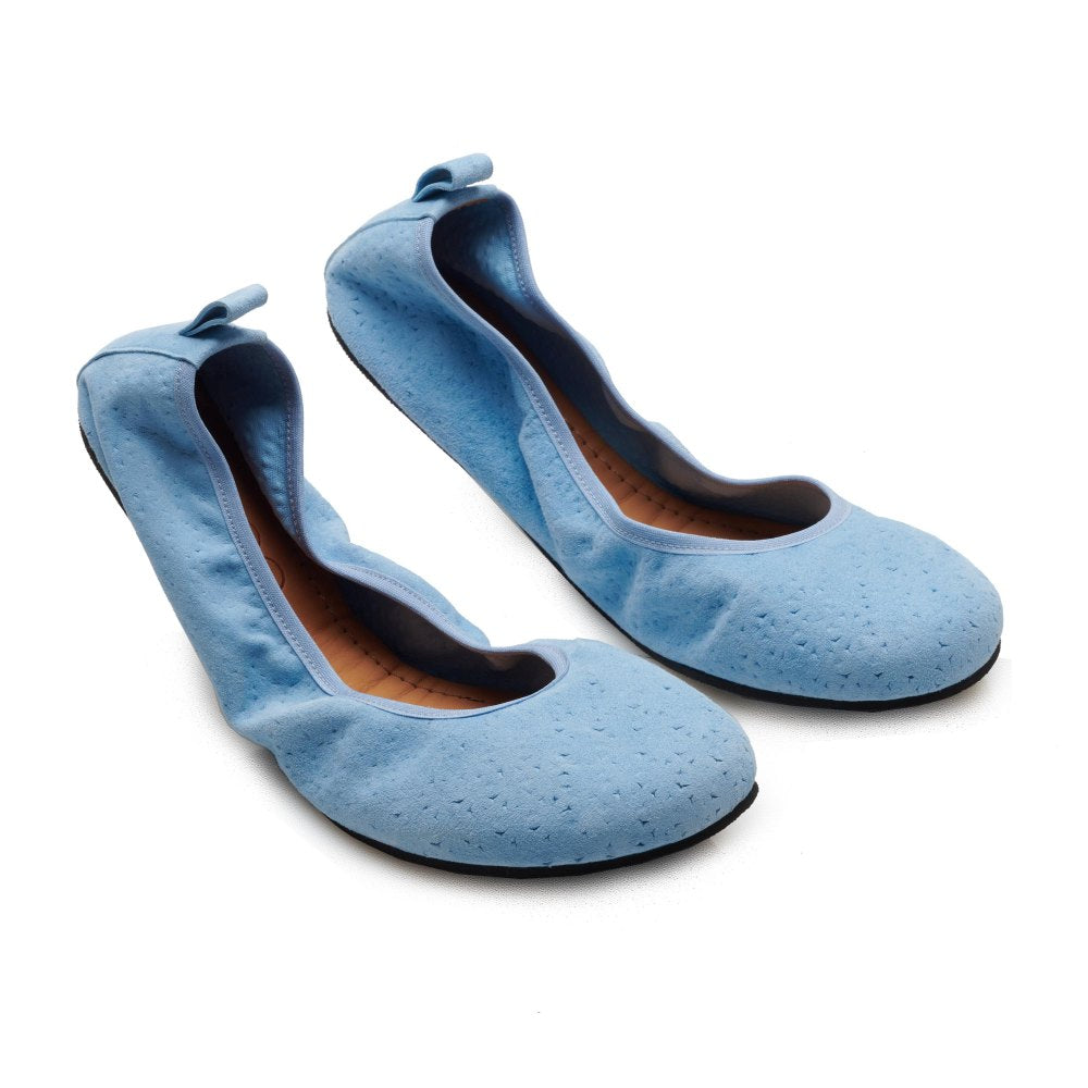 Die TWIST Light Blue Ballerinas von ZAQQ eignen sich perfekt für sommerliche Looks und bestechen durch ihre gewellten Kanten und kleinen Schleifen auf der Rückseite, die sich elegant auf einem weißen Hintergrund abheben.