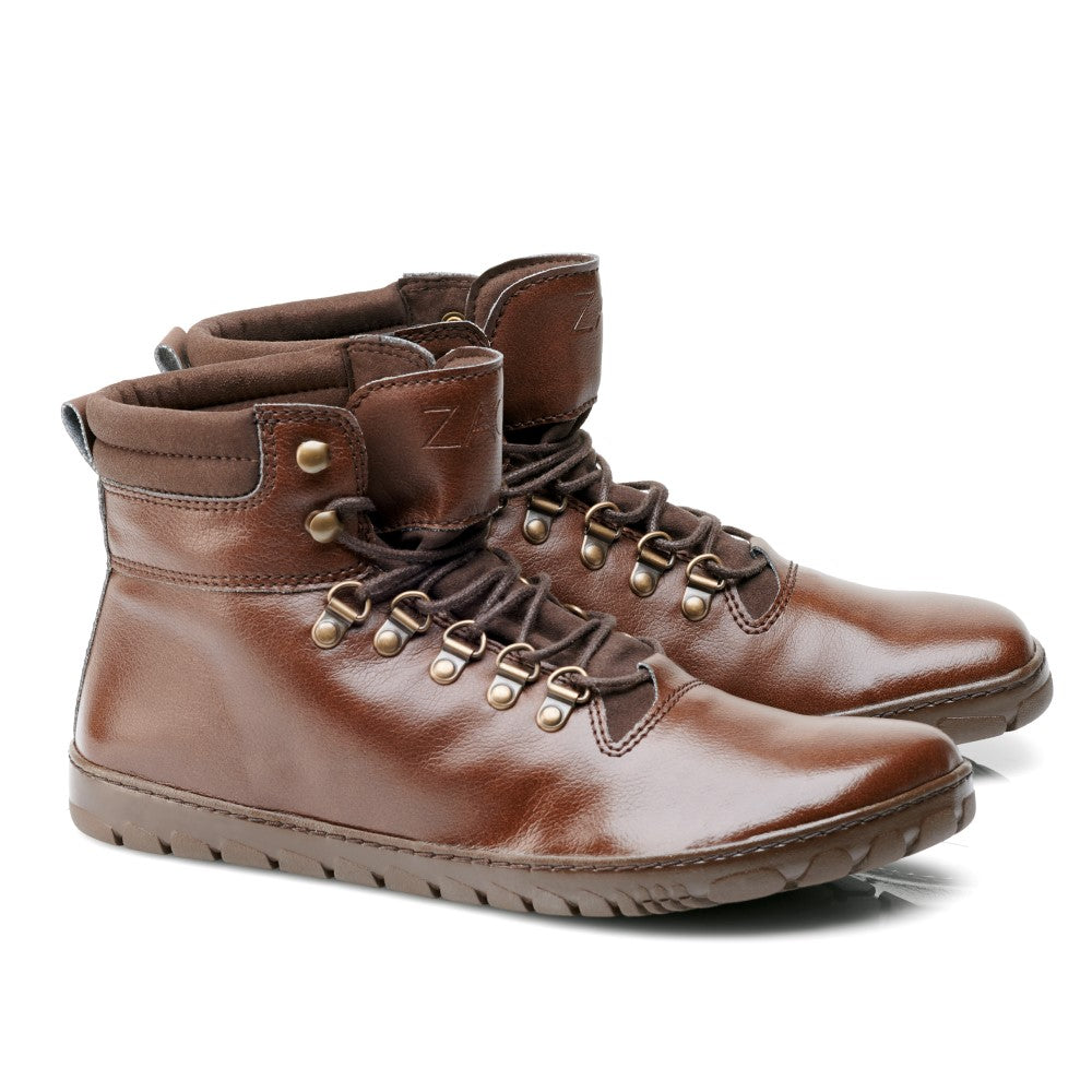 Ein Paar EXPEQ Vegan Marone Waterproof-Stiefel von ZAQQ in Braun, mit hohem Schaft und dunkelbraunen Schnürsenkeln. Diese Stiefel haben einen leicht gepolsterten Schaft, Metallösen und sichtbare Nähte. Die Sohlen sind für Traktion mit einem einfachen Profilmuster strukturiert und leicht zur Seite geneigt.