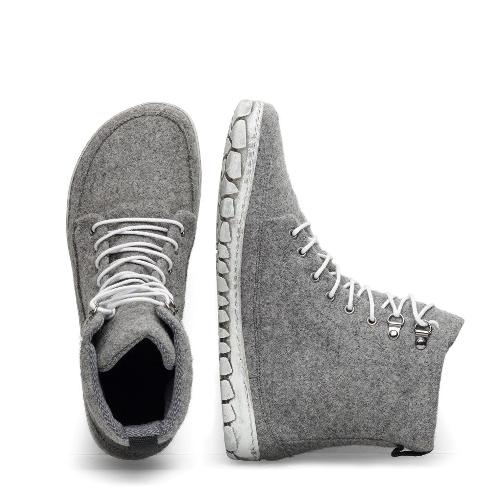 Wir präsentieren den QICE Grey von ZAQQ: Diese Sneaker haben ein High-Top-Design in Grau mit weißen Schnürsenkeln und bieten sowohl von oben als auch von der Seite einen guten Blick. Ihr herausragendes Merkmal ist eine einzigartig strukturierte Outdoorsohle, die für mehr Stil und Komfort sorgt. Sie sind aus Merinowolle ähnlichen Materialien gefertigt und bieten eine auffällige Mischung aus Komfort und Mode.