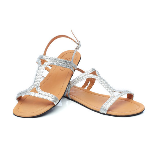 Ein Paar geflochtene Sandalen „QOSTA Silver“ von ZAQQ mit flacher brauner Sohle und Slingback-Riemen, ideal für Sommermode, präsentiert vor einem weißen Hintergrund.