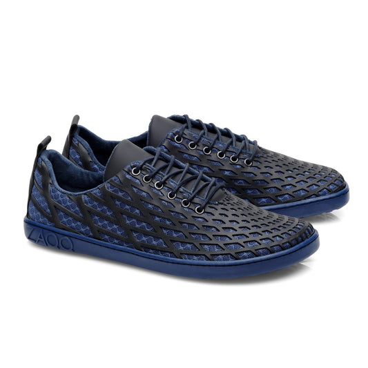 Wir präsentieren den SPIQE Blue Black von ZAQQ: Diese stylischen Sneaker zeichnen sich durch ein einzigartiges Gitterdesign in Marineblau mit eleganten schwarzen Akzenten aus. Die Schuhe verfügen über eine modische blaue Sohle und dunkle Schnürsenkel und verkörpern sowohl Stil als auch ethische Handwerkskunst.